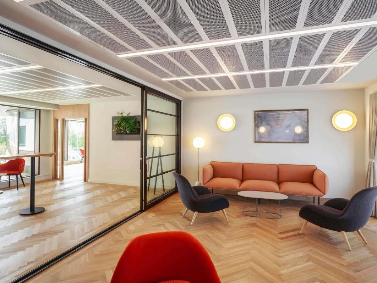 a living room with a couch and chairs at Novotel Cambridge North in Cambridge