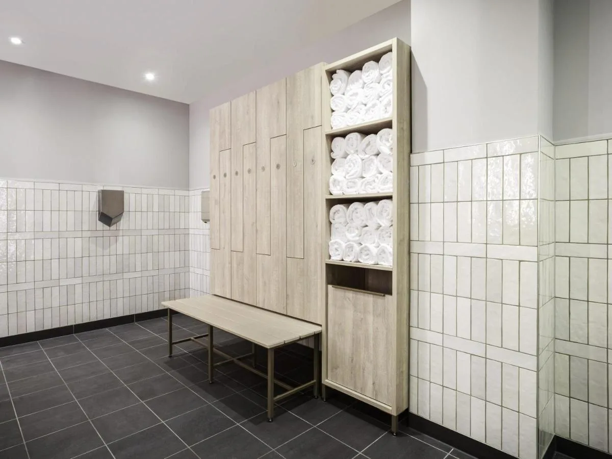 a locker room with a bench and plates at Novotel Cambridge North in Cambridge